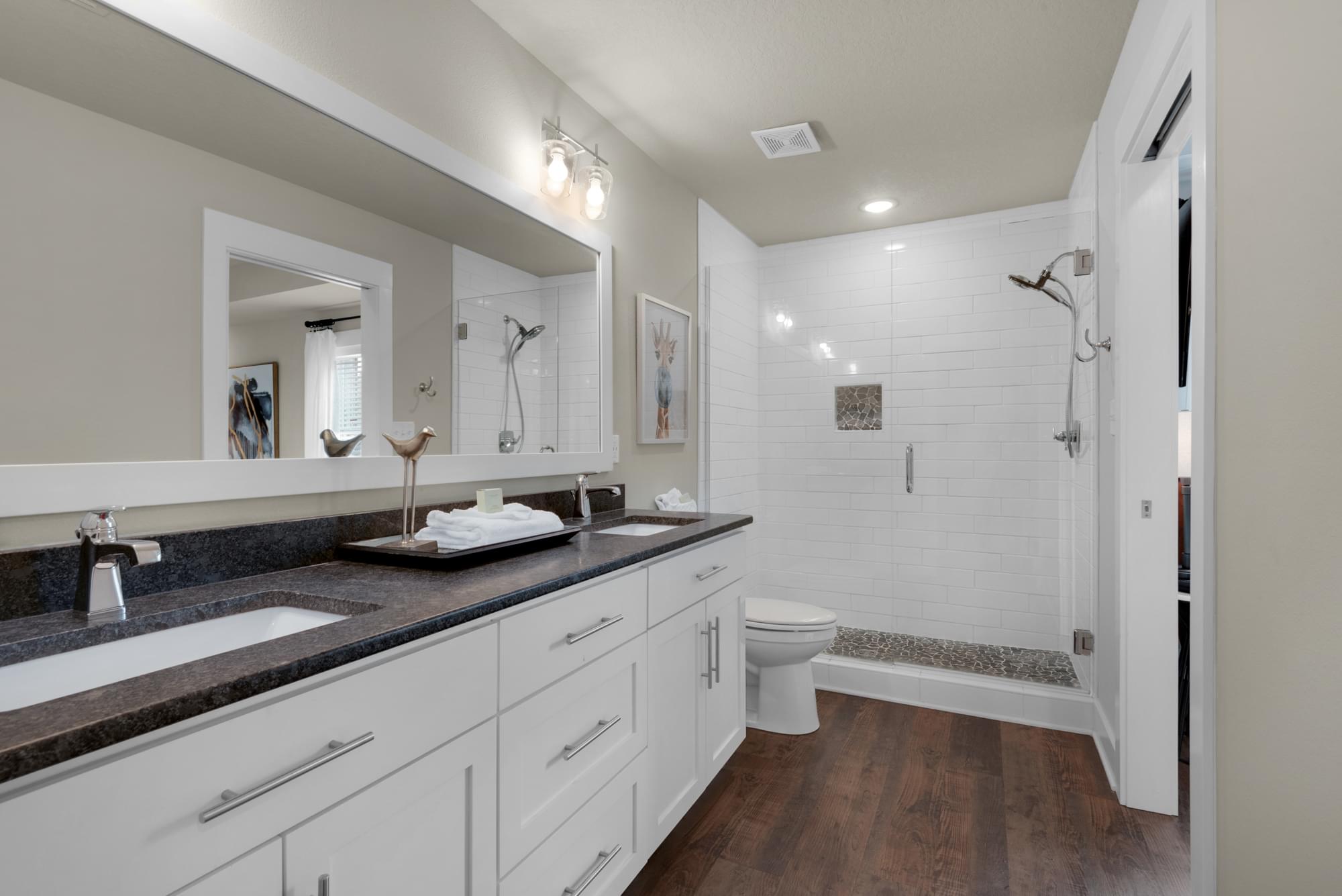 Simple, modern, elegant interior bathroom with granite tile, wood floors, and white tile.