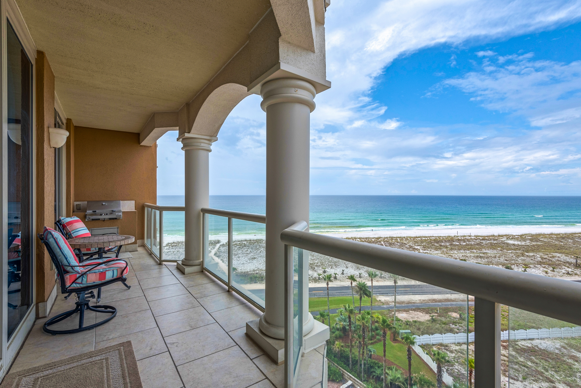 Balcony view of the Gulf Coast, beach, palm trees, white sands.
